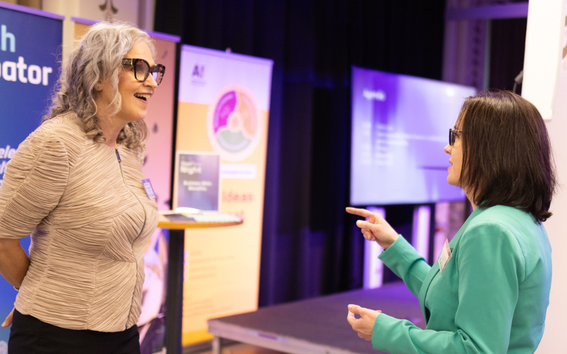Two women smiling talking to each other at one of Aalto Startup Center's event