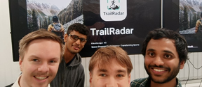 The TrailRadar team, 4 young men looking at the camera and behind them a screen with the trailradar logo on it