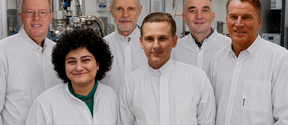The SisuSemi team in lab coats, smiling at the camera. 6 people, 5 men and 1 woman