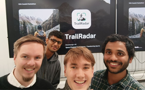 The TrailRadar team, 4 young men looking at the camera and behind them a screen with the trailradar logo on it