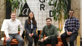 The Deltan Labs team at the A Grid premises. 4 people (3 men and 1 woman) sitting down smiling at the camera