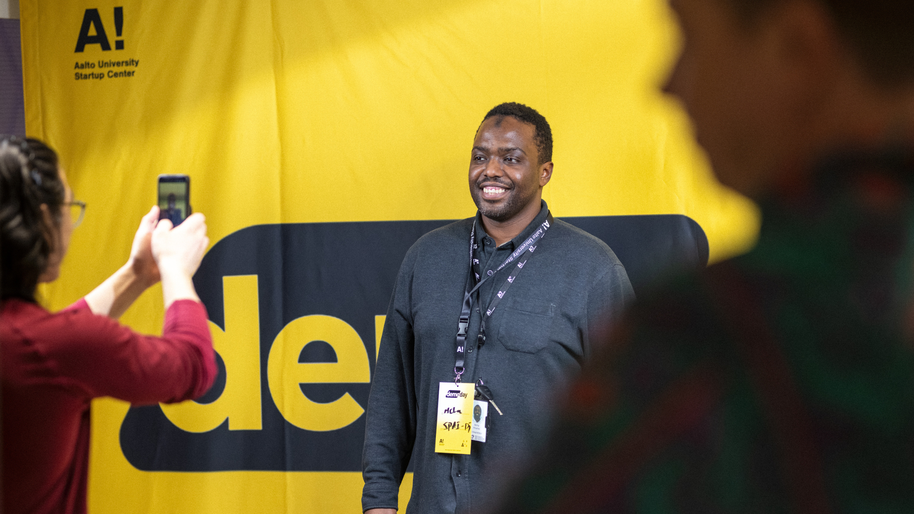 An attendee taking a picture at the Demo Day photowall