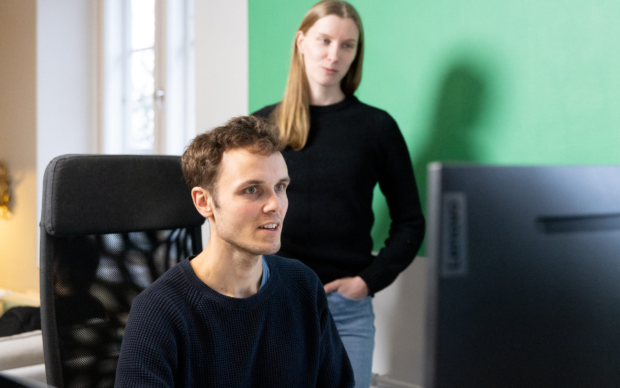 KOKO Forest team, two of them, one sitting down and another behind this one, looking at a screen
